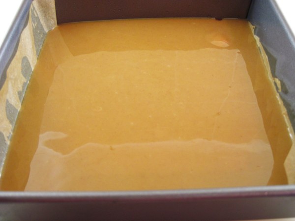 Caramel filling poured over shortbread