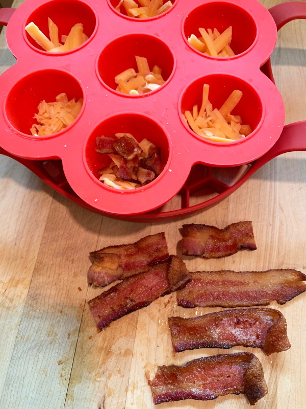 Cheese in the egg cups, adding bacon